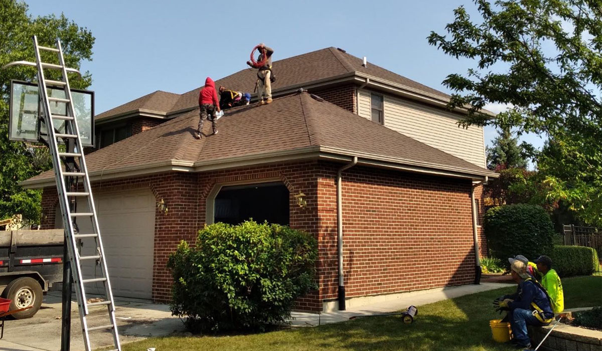 roofer on top of a house roof for roof inspection