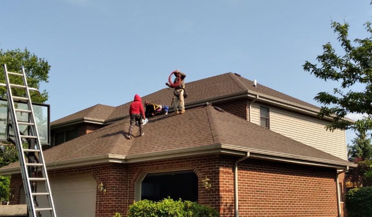 a group of workers cooperating to install new roofs