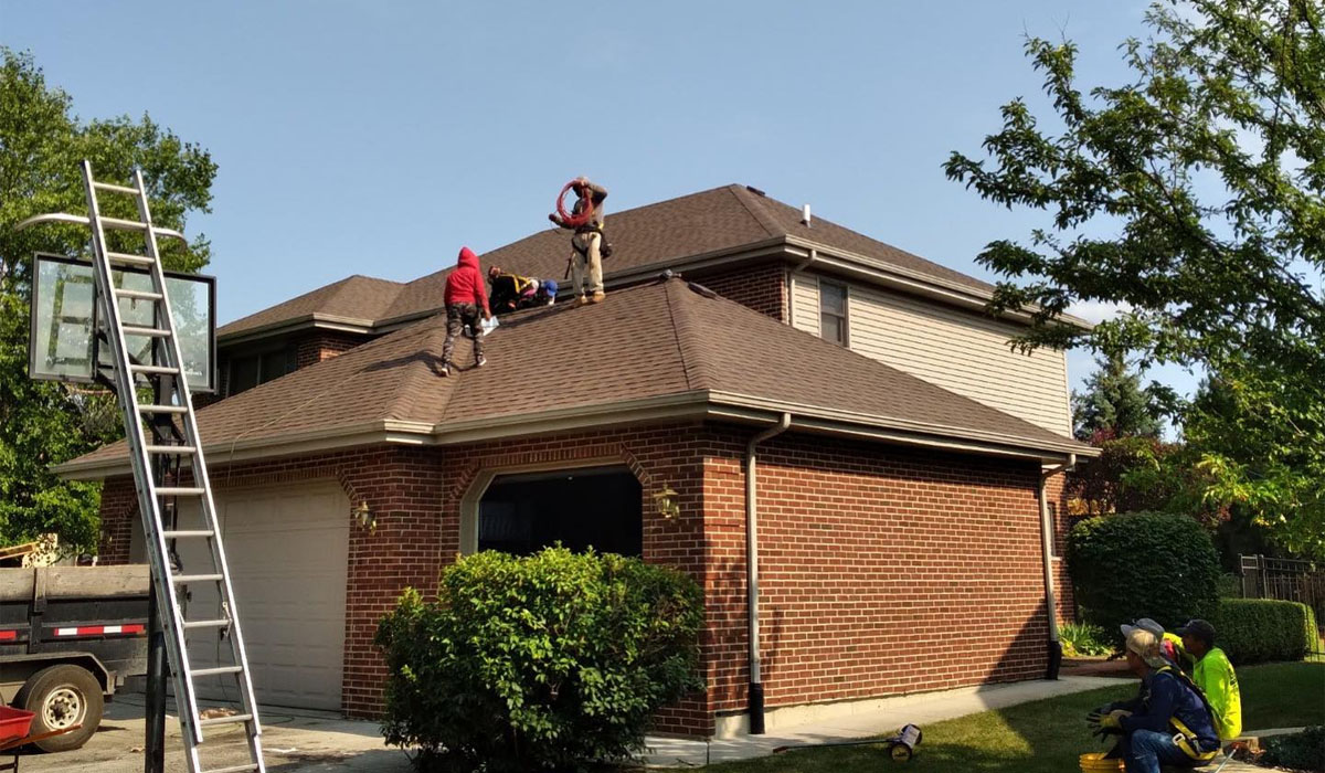 professional roofers working on top of the roof