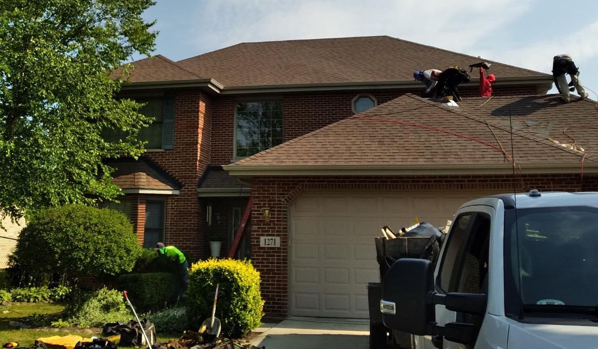 professional roofers working to replace a new roof of a house